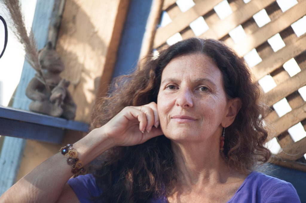 Image of author, poet, teacher, and dancer Cheryl Pallant. She is facing the camera, smiling.