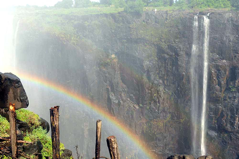 Image of a rainbow at Victoria Falls in Zimbabwe. Photo credit: K.J. Howe, award-winning author of the Thea Paris series.